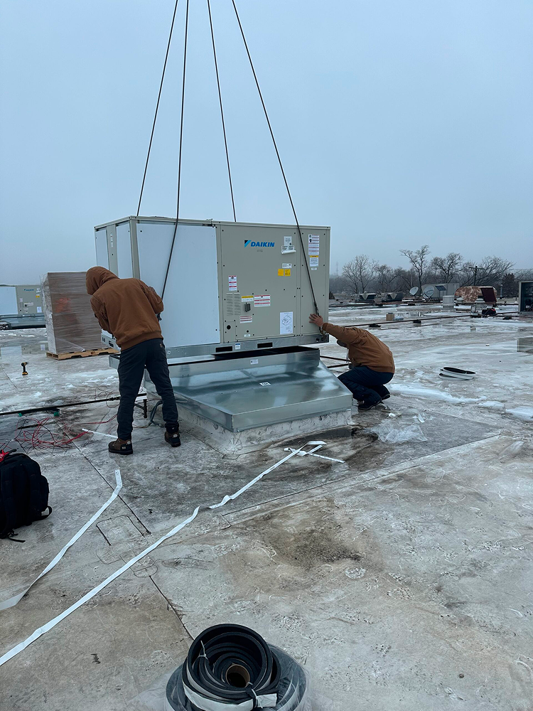 two technicians working on ac units