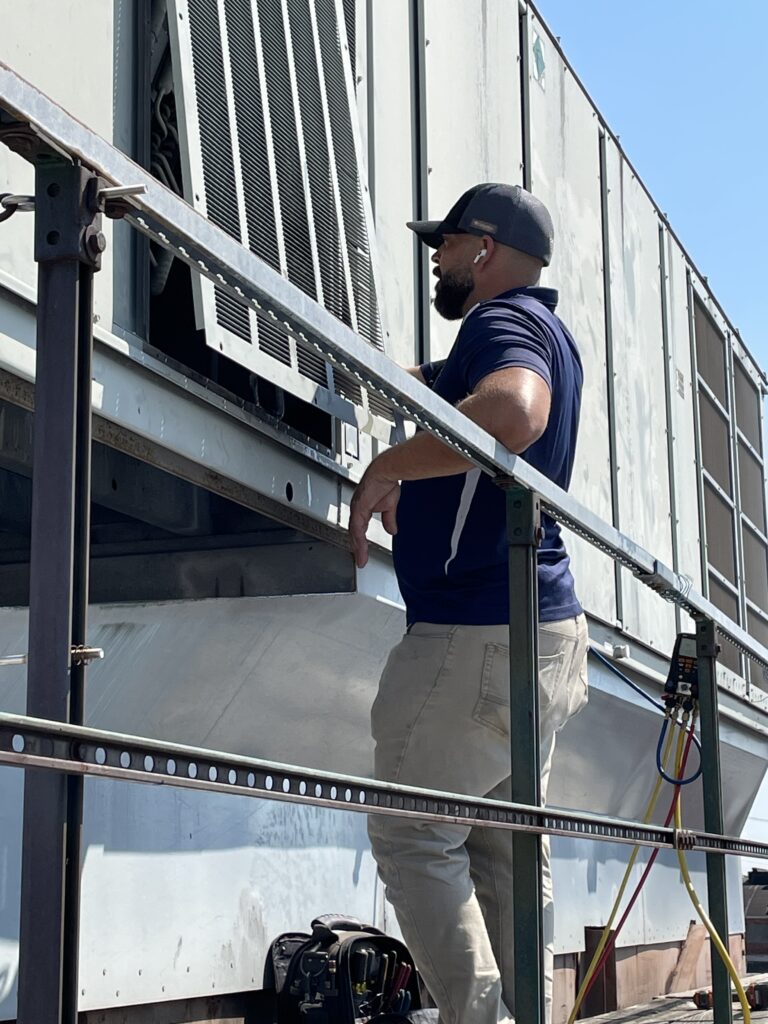 Technician in front hvac unit in kansas city, mo