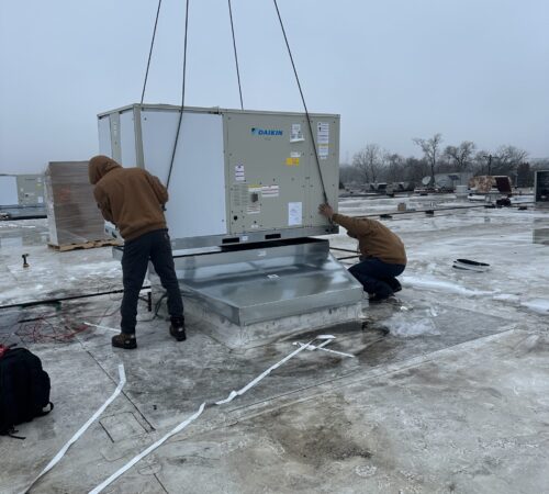 Two working on roof top with crane