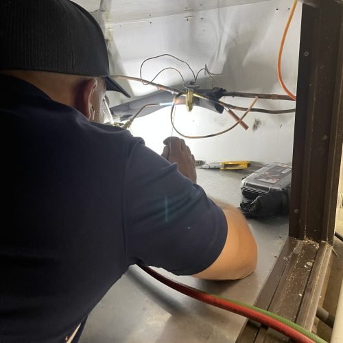 technician inside attic wiring in olathe,KS